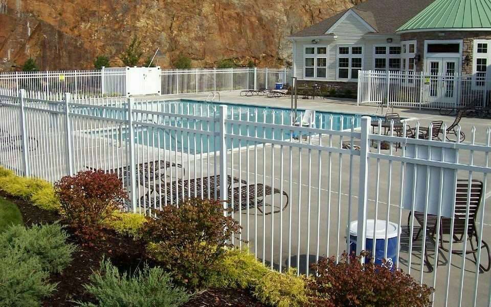 An AFS Spear Top White Aluminum fence protects the swimming area of a large residence