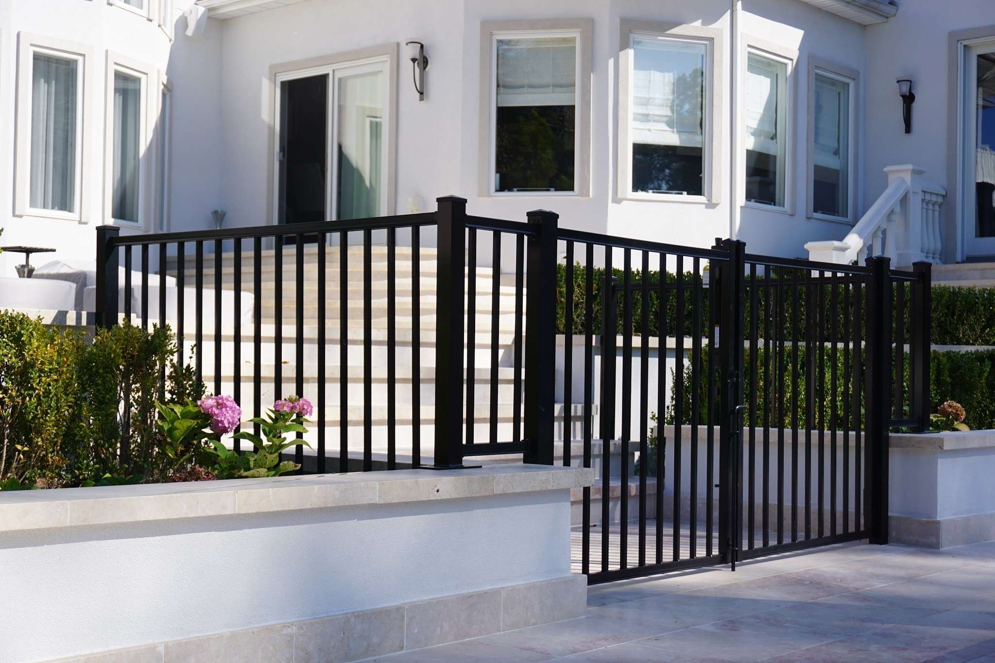 The front porch of a white modern residence with an Ay Bedrock Aluminum Gate